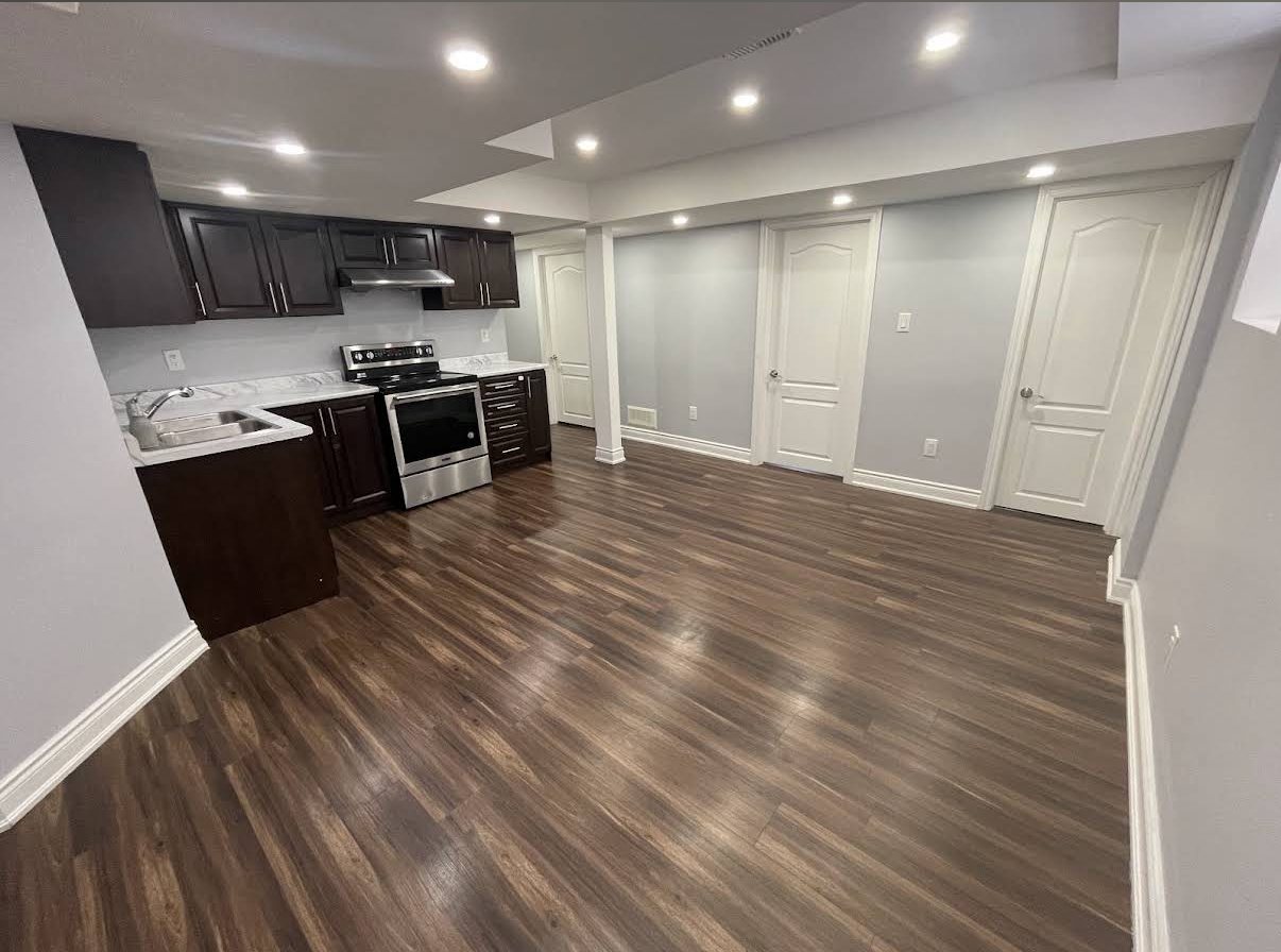 Finished basement kitchen and hallway with freshly painted grey walls and white trim in the GTA