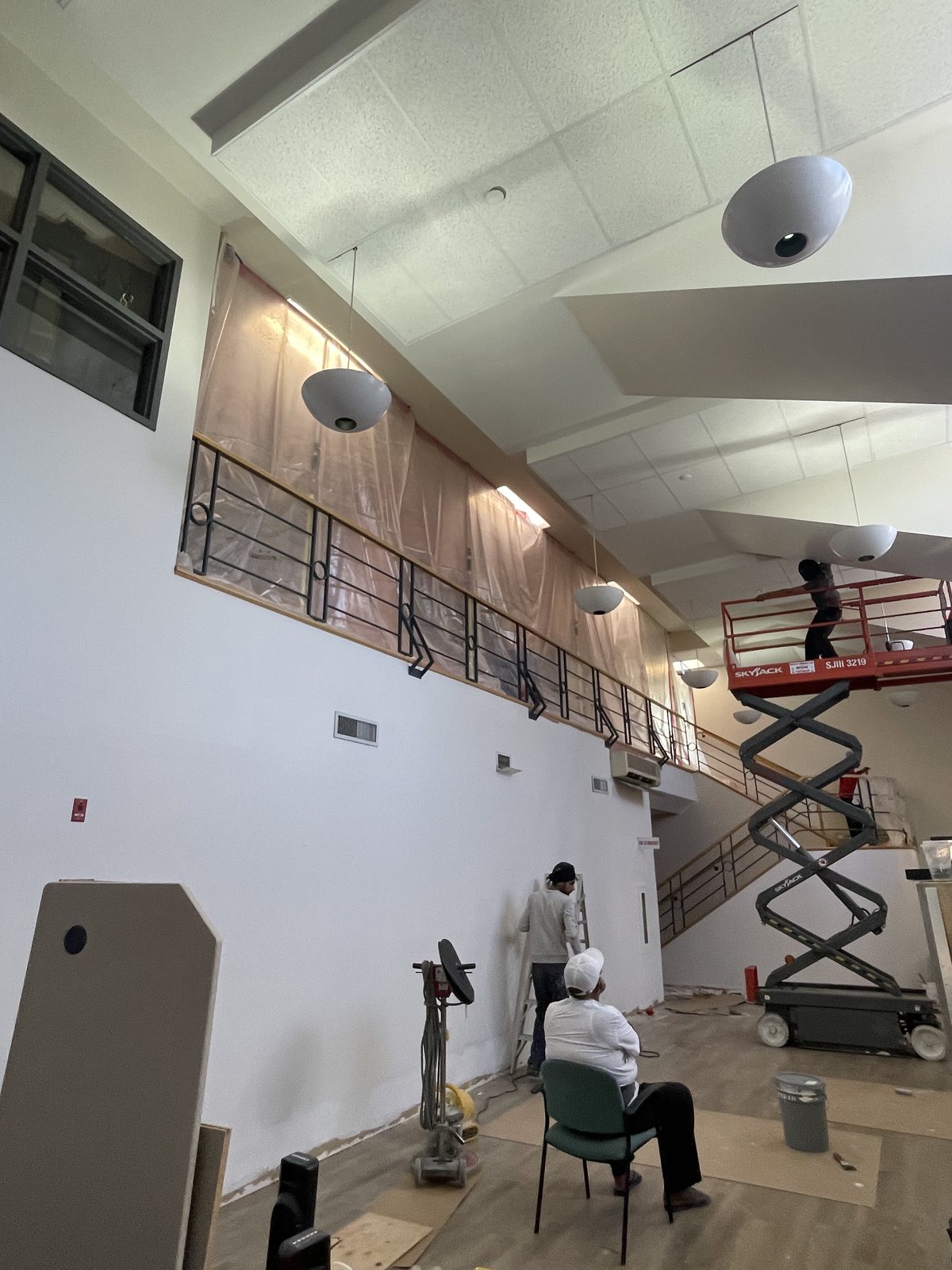 TrueCoat Painting crew on a scissor lift painting a mezzanine wall for a commercial project in Brampton