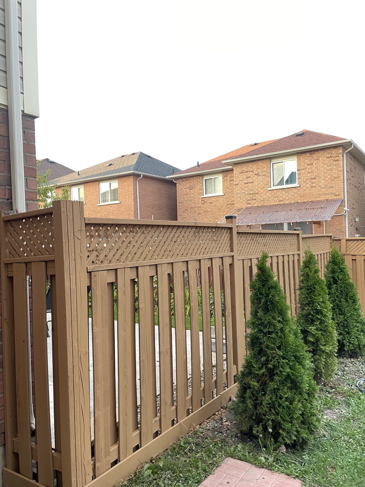 Stained wood privacy fence with lattice top by TrueCoat Painting in Brampton